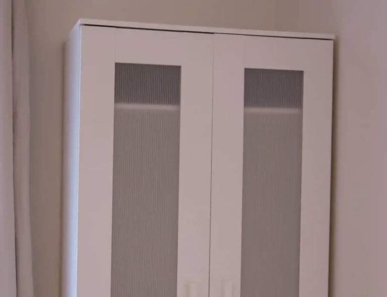 Built-in wardrobe in adult family home bedroom with shelves and hanging space for resident clothing.
