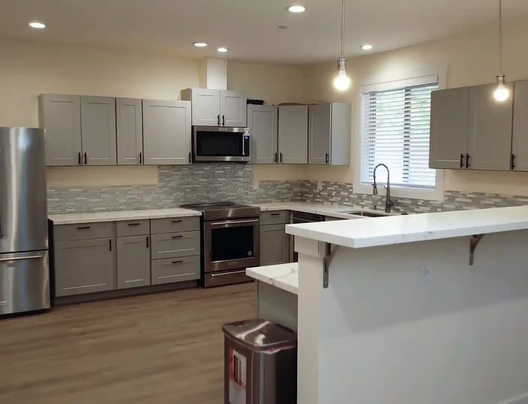 Home-style kitchen in adult family home with stove, refrigerator, and meal preparation space.