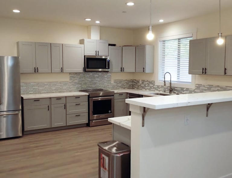 Home-style kitchen in adult family home with stove, refrigerator, and meal preparation space.