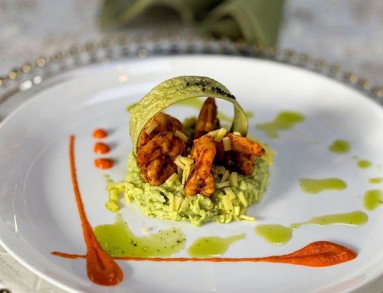 Gourmet grilled shrimp appetizer served on a bed of creamy avocado mousse with red pepper coulis.
