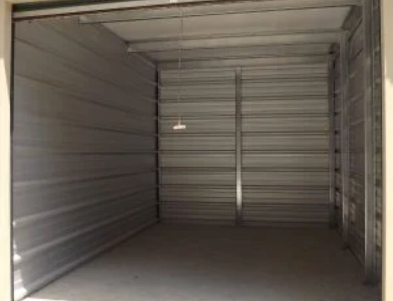 An empty 10X15 foot clean self-storage unit with metal walls and a concrete floor.