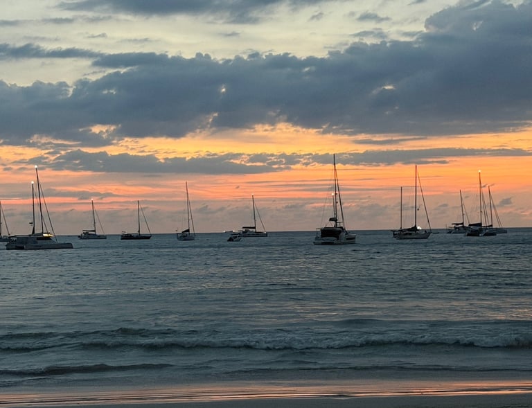 Sunset ocean view with sailing yachts anchored at Nai Harn bay Phuket