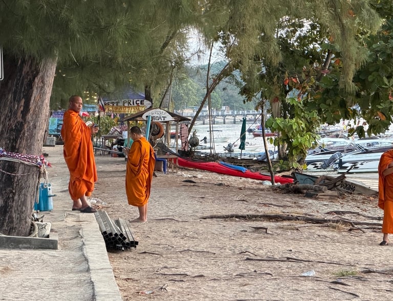 Buddhist monks in orange robes walking near the beach in Rawai Phuket