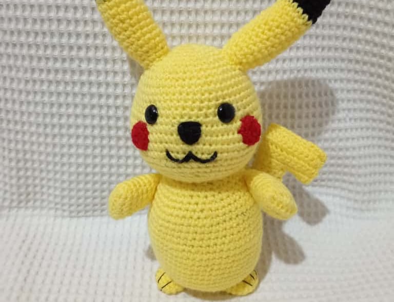 Handmade yellow crochet Pikachu amigurumi plush toy featuring iconic red cheeks and pointed ears.