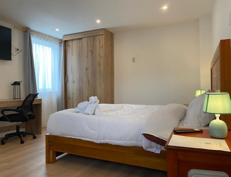 Habitación matrimonial elegante con escritorio, tv y cafetera en Condor Palace Hotel en Huayllay