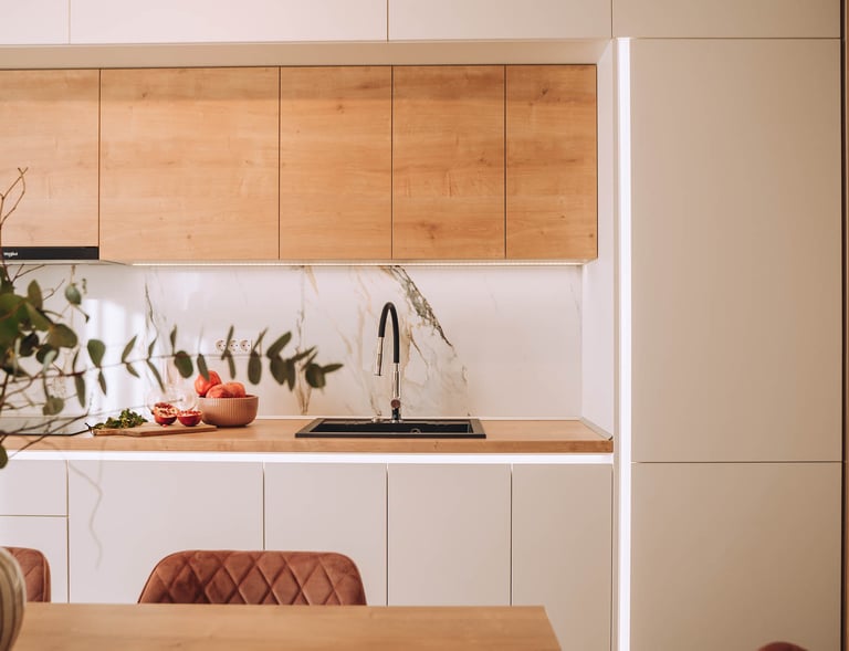 oradea Modern kitchen design featuring wood cabinets, white marble backsplash, and a black sink.