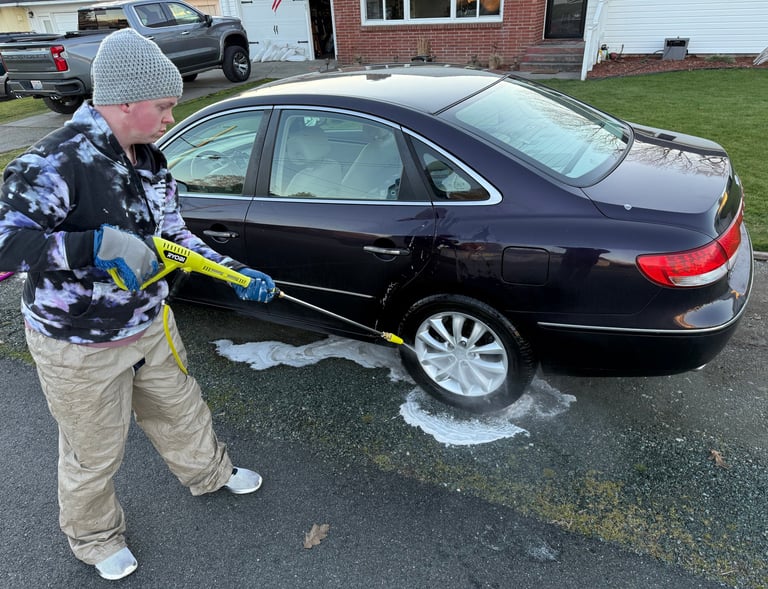 person pressure washing car tire