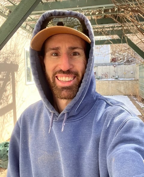 a man in a blue hoodie and a hat