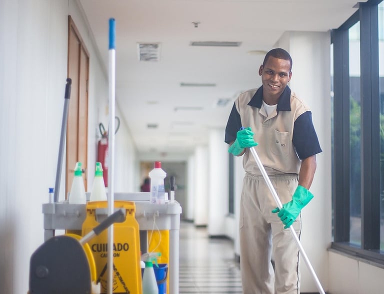 a man in a uniform cleaning a hallway