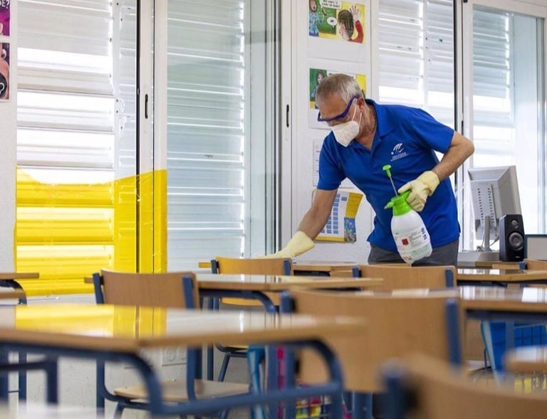 a man in a blue shirt and a white shirt cleaning a desk