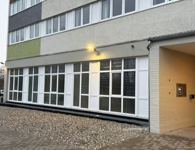 Seitenansicht mit neuer Fensterfront und farbig abgesetzter Fassade eines Wohnhauses