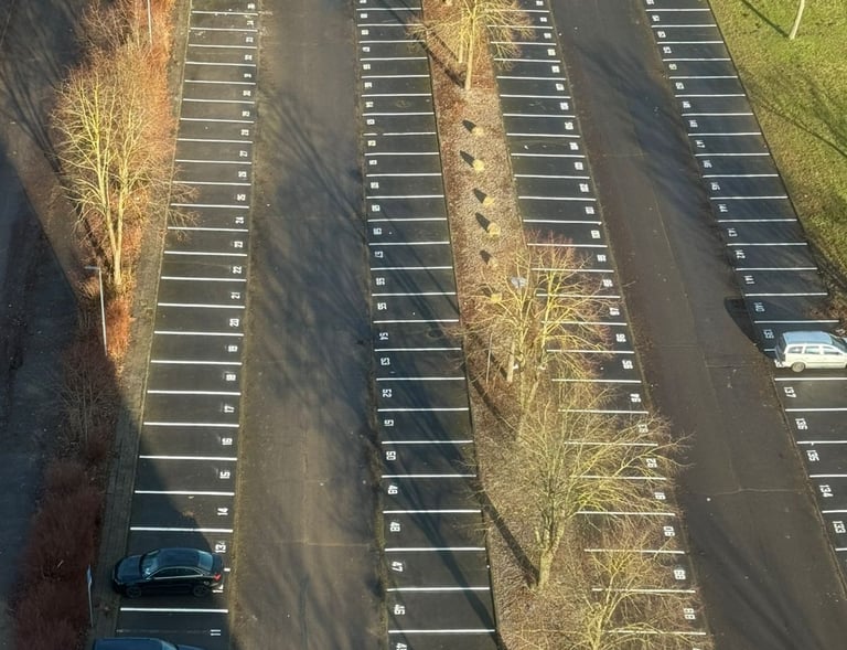 Erneuerte Parkplatzmarkierungen auf großem Stellplatz – ausgeführt von Hebestreit Generalunternehmer