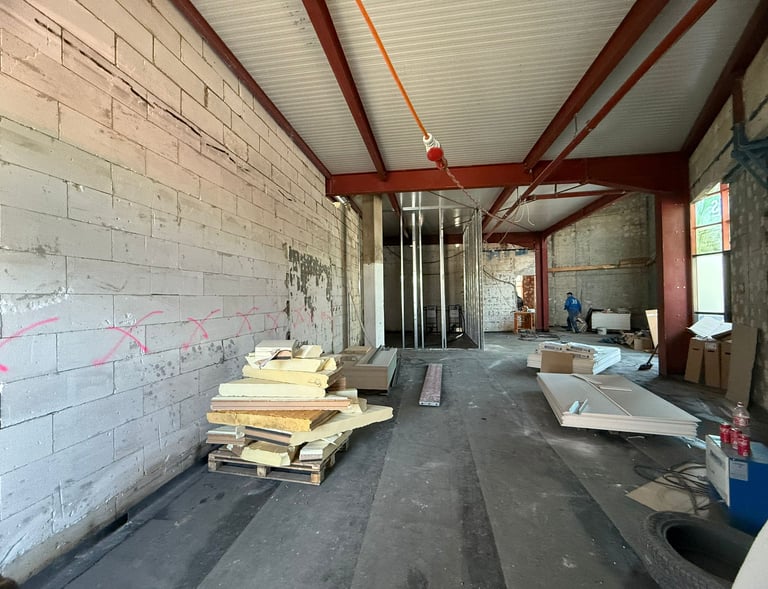 Baustelle im Innenausbau mit Dämmmaterial, Ständerwerk und offenem Deckenträger-System