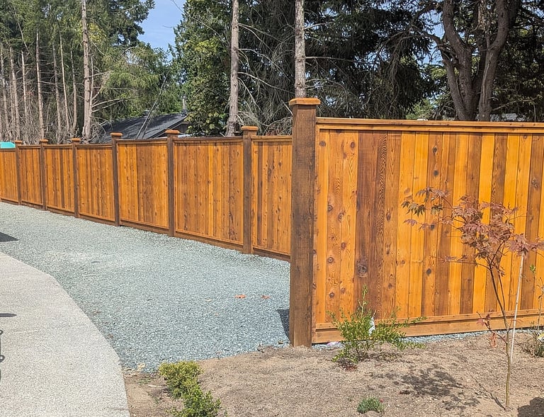 New spray-stained fencing, with tamped and leveled gravel service area