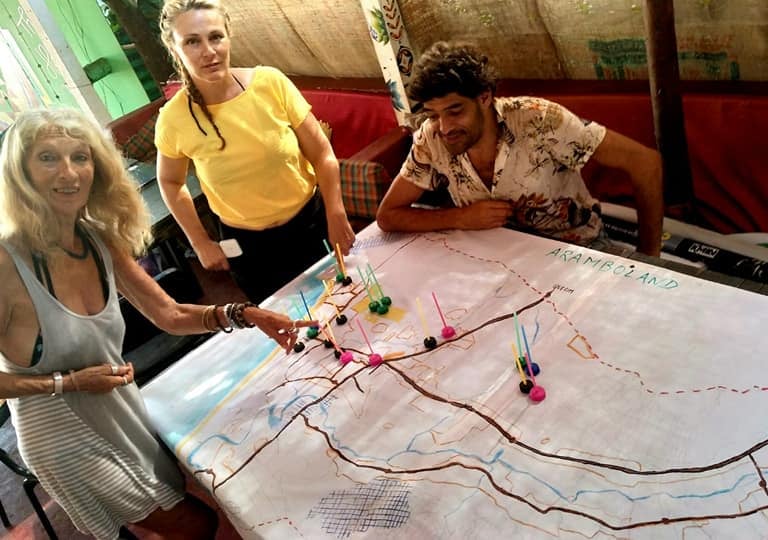 a group of people standing around a table with a map
