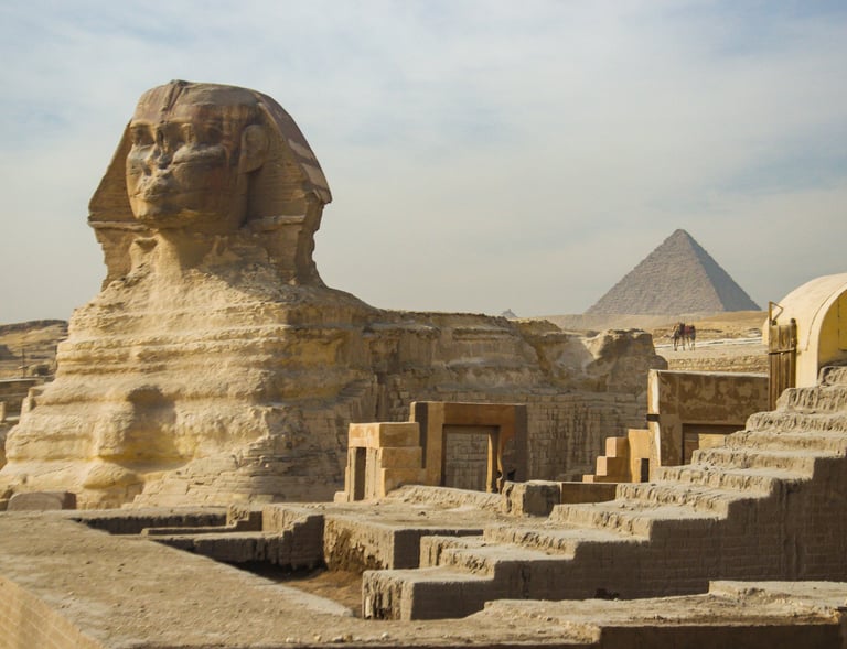 The Great Sphinx and pyramids at Giza under a clear blue sky.