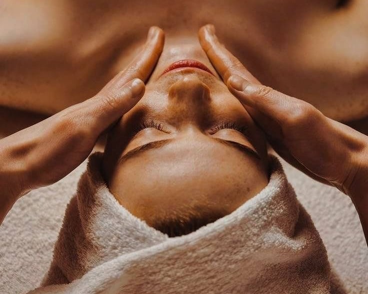 a woman getting a facial massage at a spa