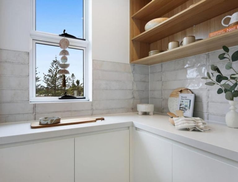 a butlers pantry with a window and a vase with flowers