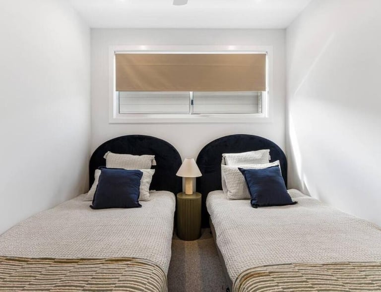 two twin beds in a room with a window