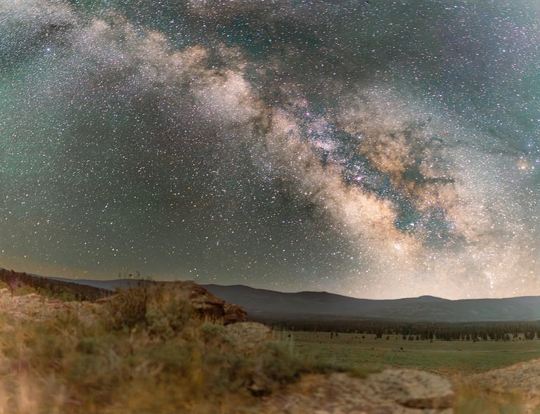 Breathtaking view of the Milky Way galaxy stretching across a starry night sky over a dark mountain landscape.