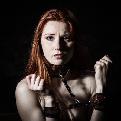 a woman in a leather bonde and leather cuffs