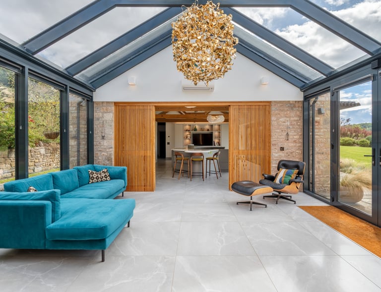a stunning entrance hall with glass walls and ceiling and a chandelier