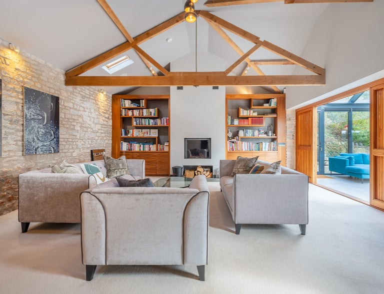 a living room with a couch and a fireplace and wooden beams