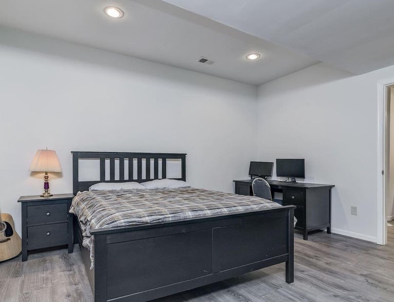 New bedroom with walk-in closet, grey LVT flooring, and recessed lighting.