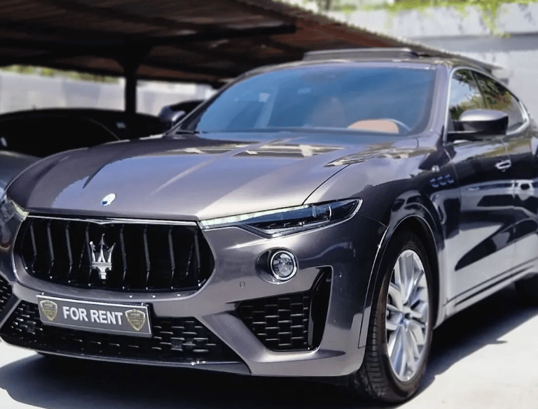 Luxury grey Maserati Levante SUV available for rent parked in a showroom lot.