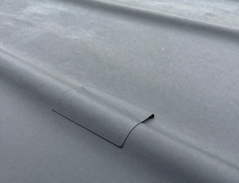 Side view of a repaired EPDM rubber roof section under bright daylight.