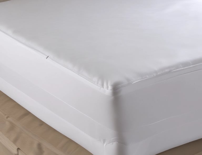 Hands adjusting a perfectly fitted qatan mattress protector on a guest bed in a hotel.
