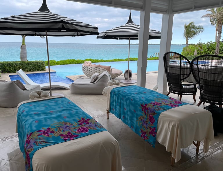 a couple of massages by sophia massage beds outside on a patio with an ocean view
