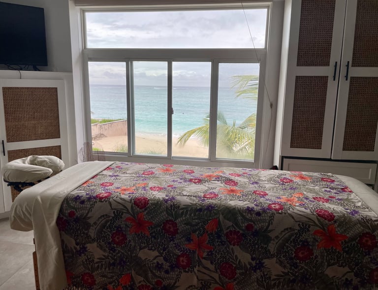 a massages by sophia massage table with a colorful sheet in a room with an ocean view