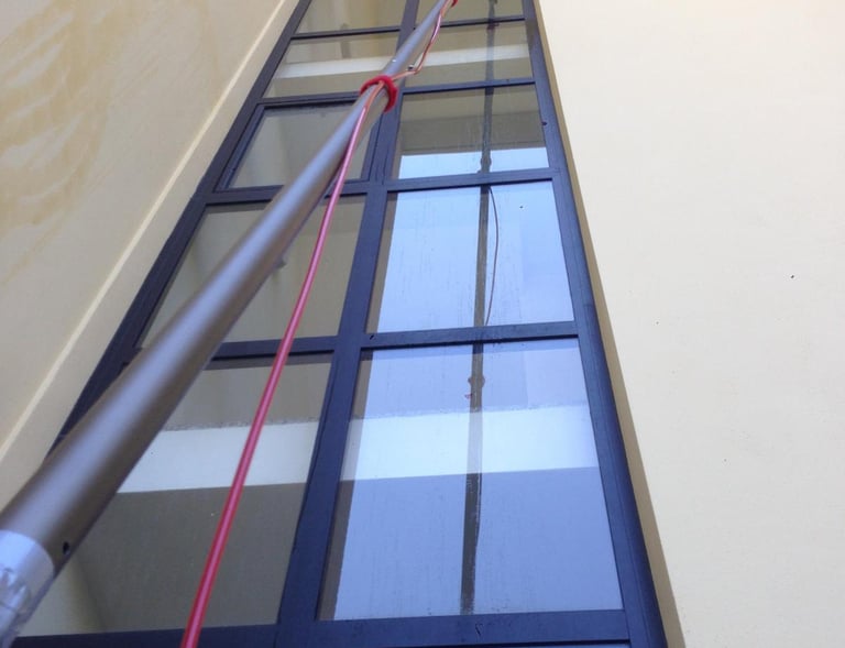 "Technicien professionnel utilisant un Perches Télescopiques spécialisé pour le nettoyage de vitres sans traces, eau osmosée