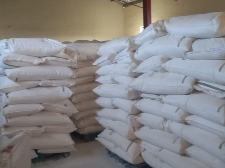 Stacks of white Tapioca Starch bags on pallets in a storage warehouse facility.
