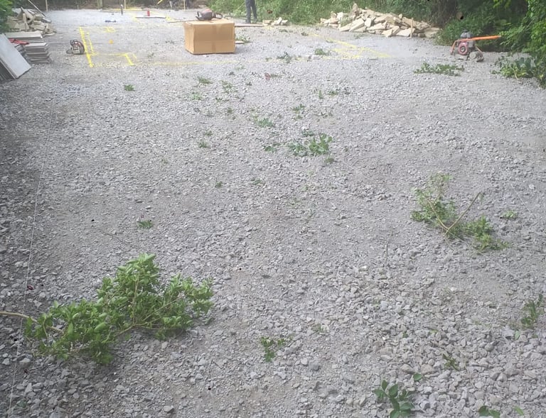a man standing in a gravel road with a box of boxes