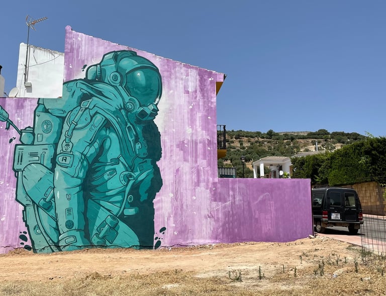 Mural a gran escala de un astronauta en la fachada de un edificio de 3 plantas