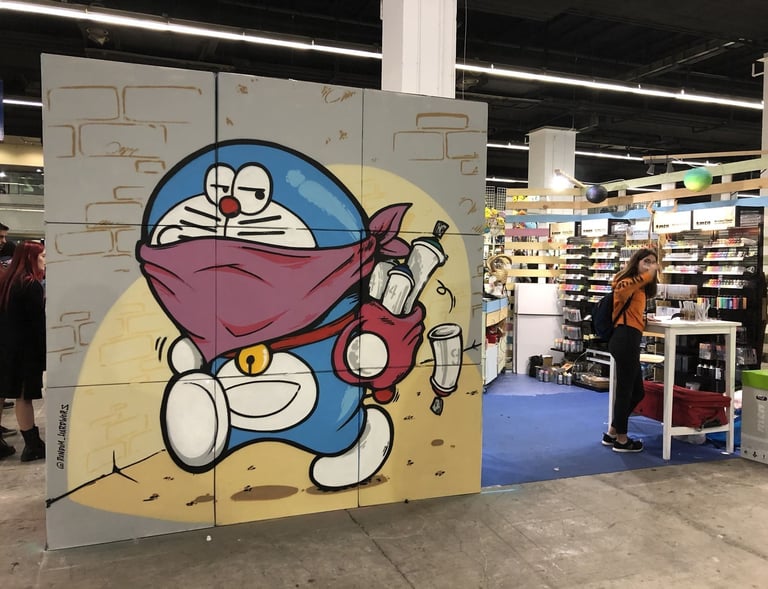 Un dibujo de doraemon en el salón del manga hecho en unos cartones. Pintura en directo.