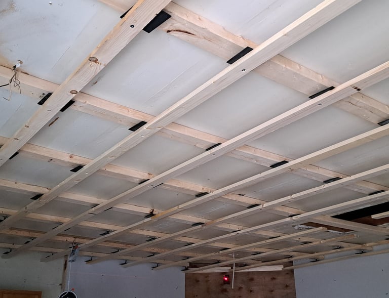 Grid-style ceiling framing structure prepared for wood panel installation during interior levelled renovation project