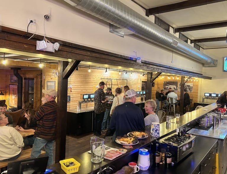 Guests roaming freely near the living room, community tables and self-service taps