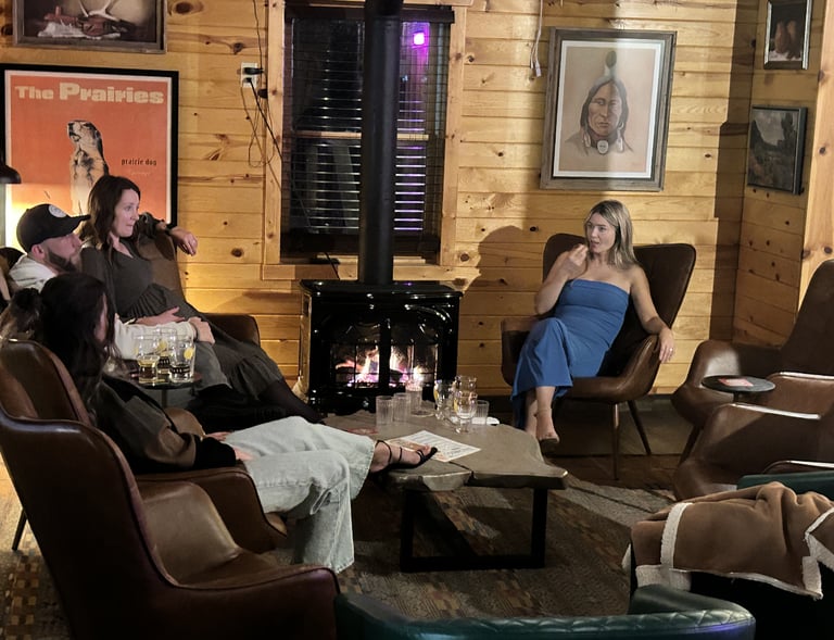 A private party group of people sitting in chairs in The Prairie Dog ;living room