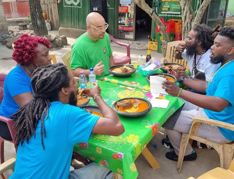 Sankofa Flamingo in Ahanta, Ghana, sitting around a table eating