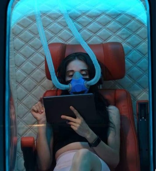Persona respirando oxigeno en cámara hiperbárica