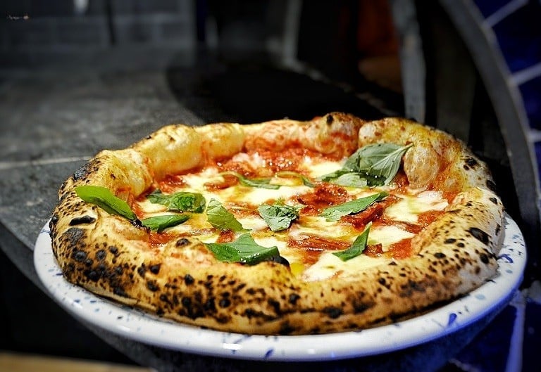 Véritable pizza napolitaine Margherita cuite au feu de bois par le foodtruck Pépé Rony, avec basilic