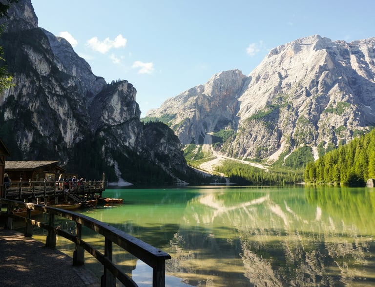 a mountain scene with a lake and a boat dolomites italy