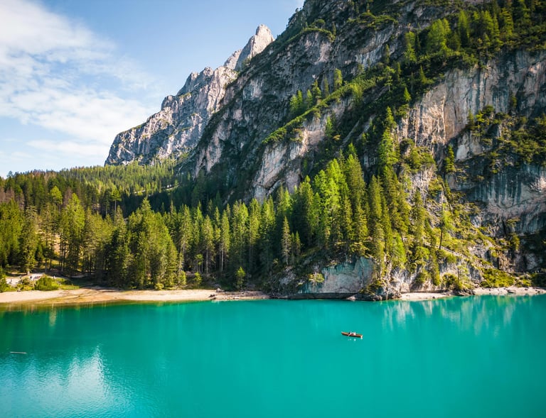 a boat in the water near a mountain dolomites italy