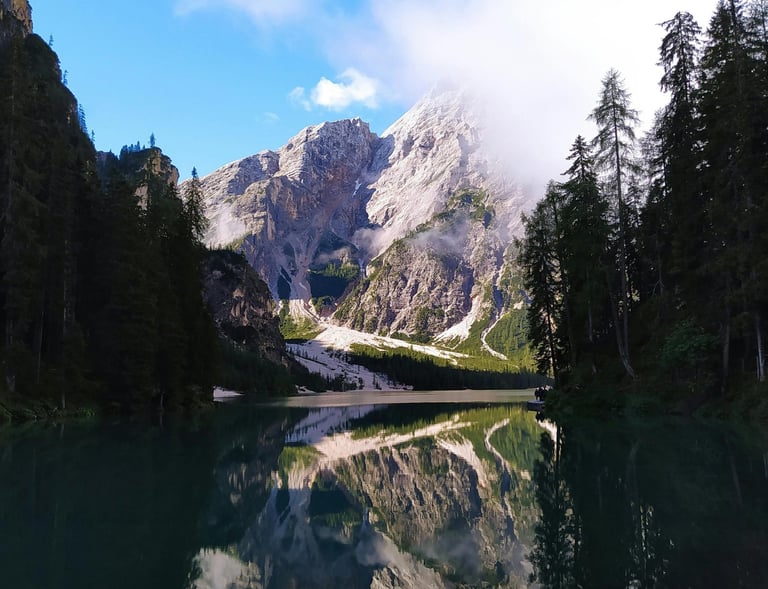 a mountain scene with a lake and a bridge