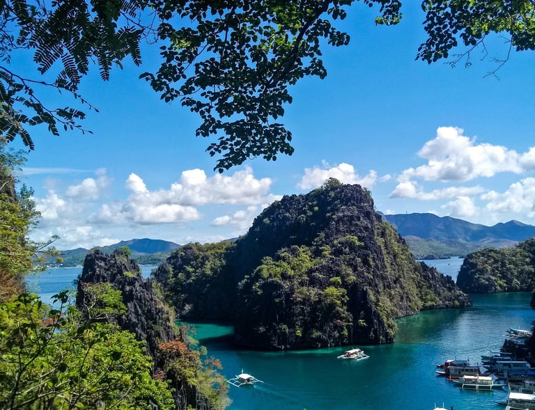 a view of a bay with boats and a blue sky  El Nido Palawan