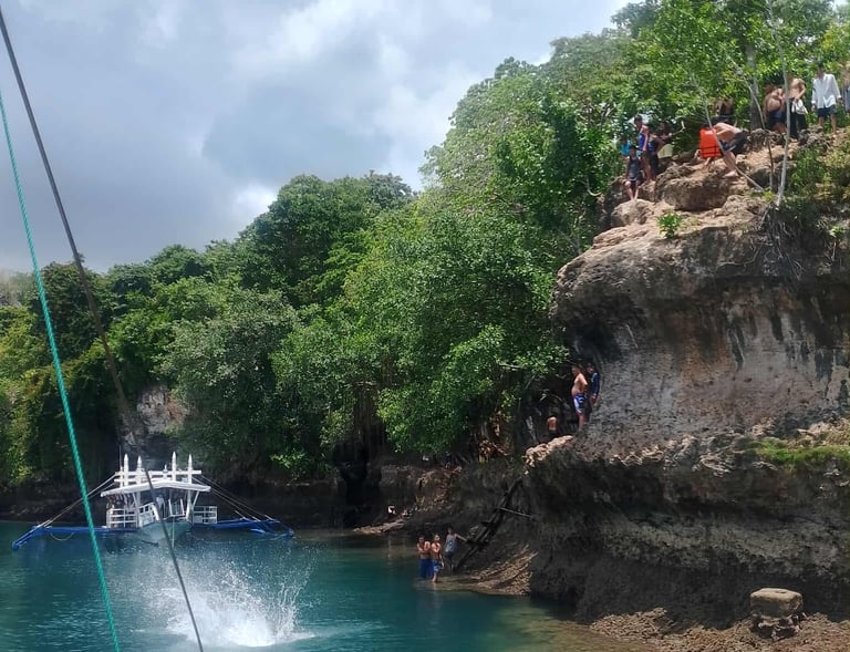 a person jumping off a boat in the water during island hopping
