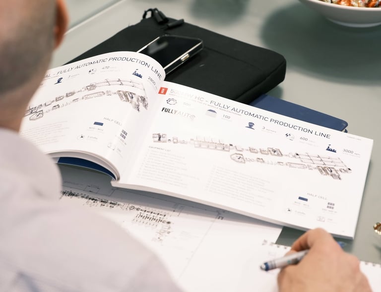Engineer reviewing a manual for a fully automatic production line at a modern manufacturing facility.
